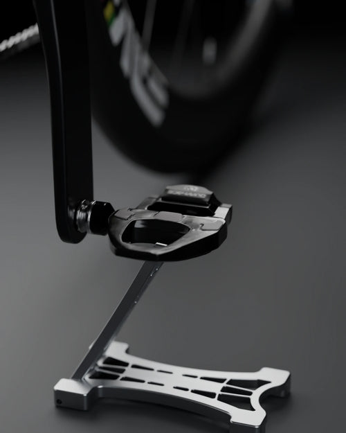 THE STAND 0.01 seen head-on under a road bike pedal, studio background